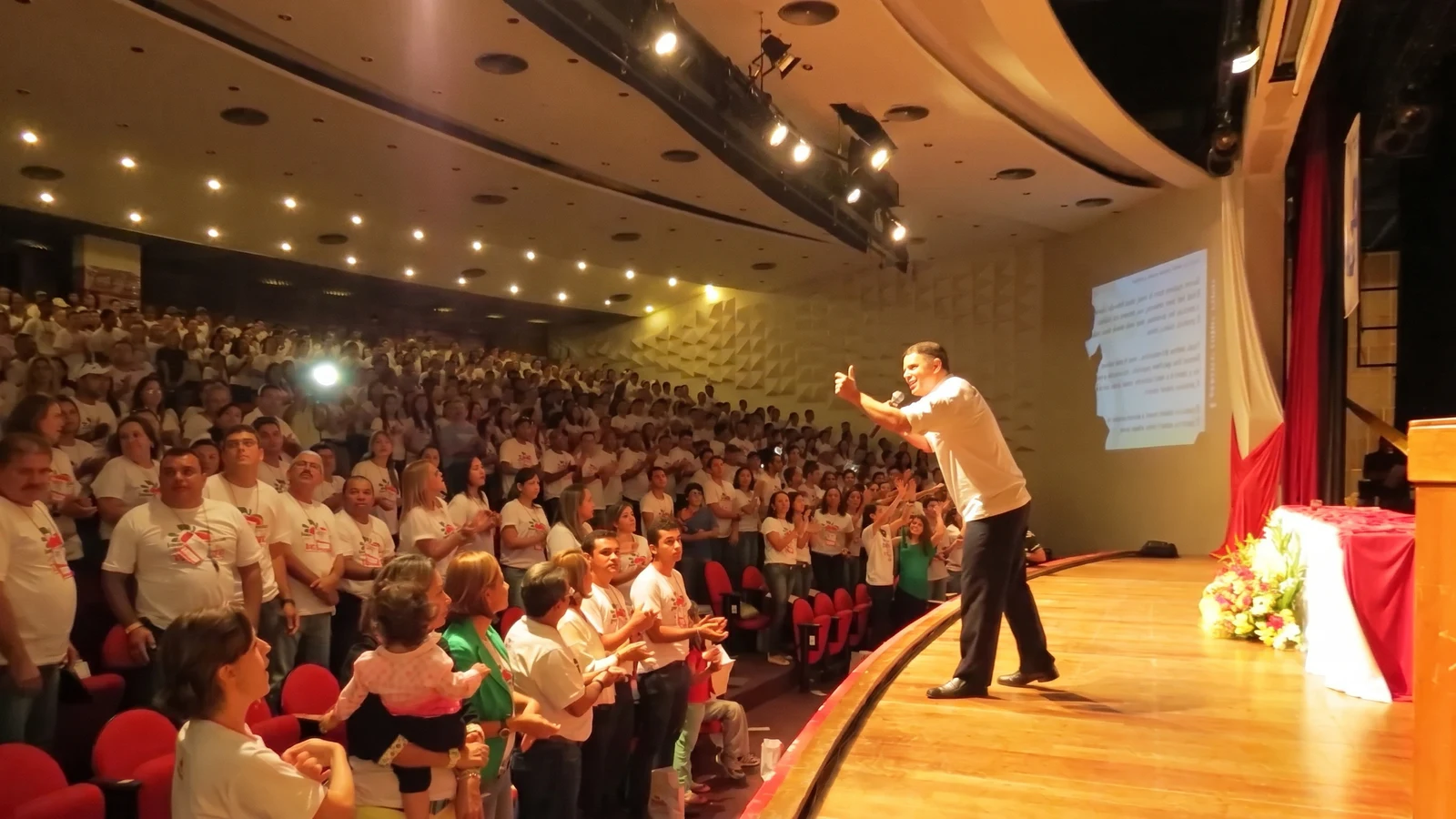 Erik Penna no palco diante de uma grande plateia durante uma palestra